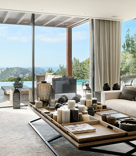 Open-plan living and dining room with natural-toned furnishings and large glazing