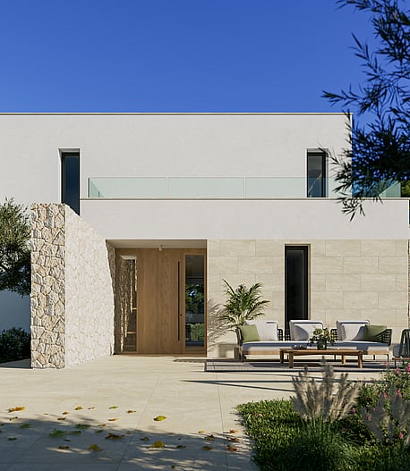 Modern villa exterior with white render and natural stone cladding, featuring a terrace area and olive trees under bright sun.