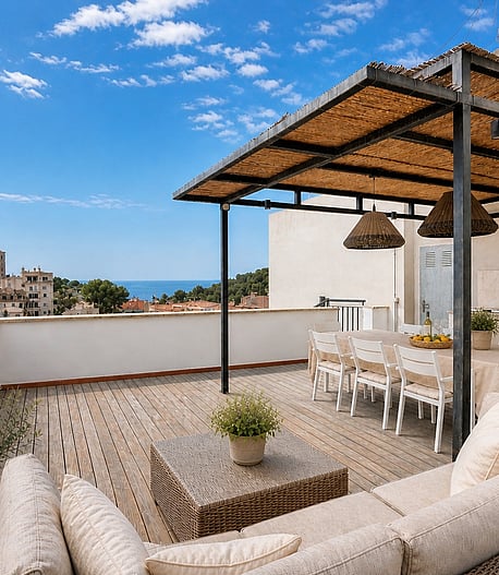 A spacious terrace in San Agustin with a shaded dining area, woven rattan sofa, and a stone-built outdoor kitchen.