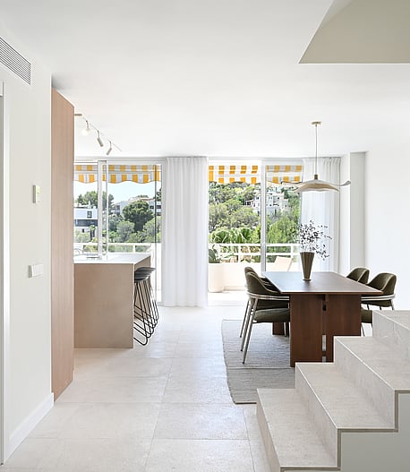 Living room with linen sofa, walnut coffee table, and floor-to-ceiling glazing framing seaview terrace