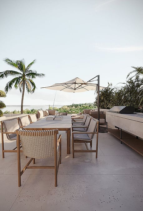 Rooftop terrace with a long outdoor dining table, woven chairs, a cantilever umbrella, and a stone prep area.