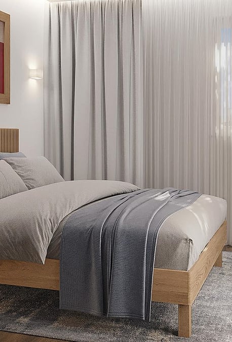 A modern bedroom featuring a light oak bed frame with a vertical-slatted headboard, soft grey textiles, a textured rug, and a wall-mounted nightstand under a framed print.