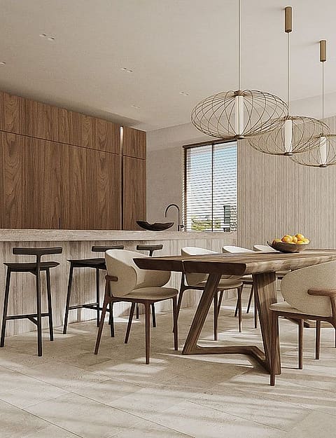 Interior view of an open-plan kitchen with a stone island, wooden cabinetry, and adjacent wooden dining table with chairs.