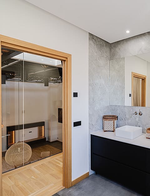 Modern bathroom featuring a black floating vanity, two white countertop sinks, a large mirror, and a glass-enclosed shower area.