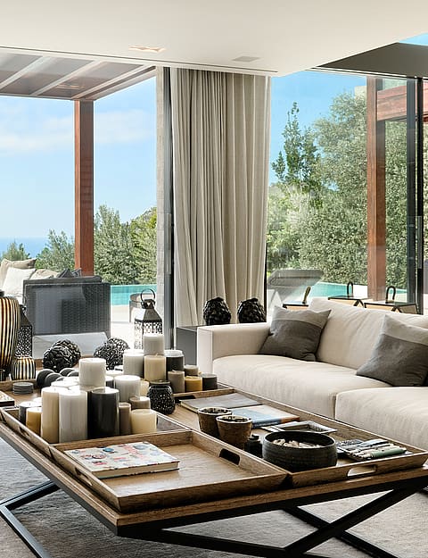 Open-plan living and dining room with natural-toned furnishings and large glazing