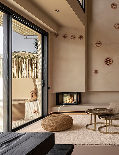 Modern living room with a textured plaster accent wall, integrated fireplace, arched shelving, and minimalist fabric sofa.
