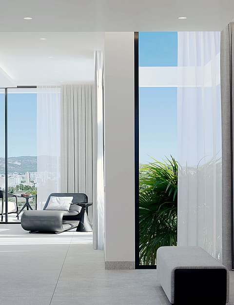 Modern interior space with light grey tile floors, featuring a dark grey lounge chair on a sunlit terrace visible through full-height sliding glass doors.