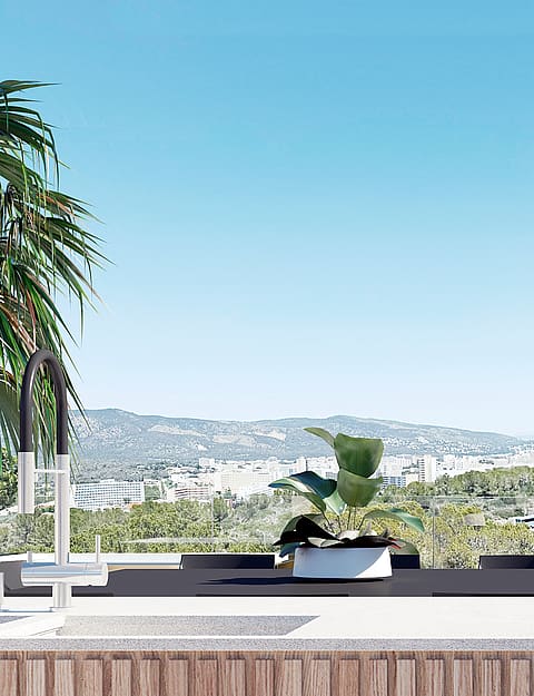 A modern kitchen island with a white countertop and fluted wood cabinetry, set against a backdrop of distant hills.