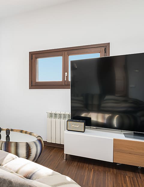 Modern living room with dark wood floors, skylight, and windows framing the Palma Cathedral.