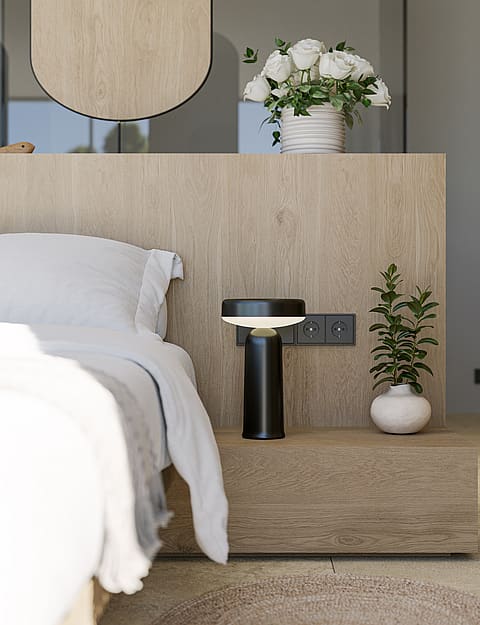 Close-up of a modern bedside setup with a textured oak headboard, black designer lamp, and a small ceramic vase.