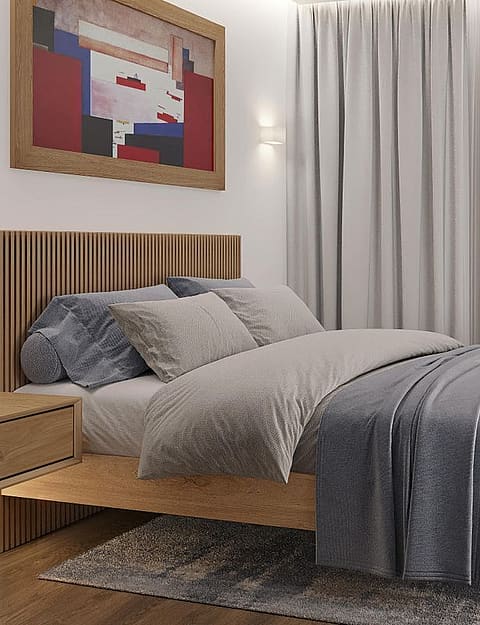A modern bedroom featuring a light oak bed frame with a vertical-slatted headboard, soft grey textiles, a textured rug, and a wall-mounted nightstand under a framed print.