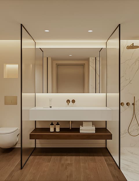 Marble en-suite bathroom with walk-in shower, brushed brass fixtures, wall-hung WC, floating basin on a timber shelf and a backlit mirror.