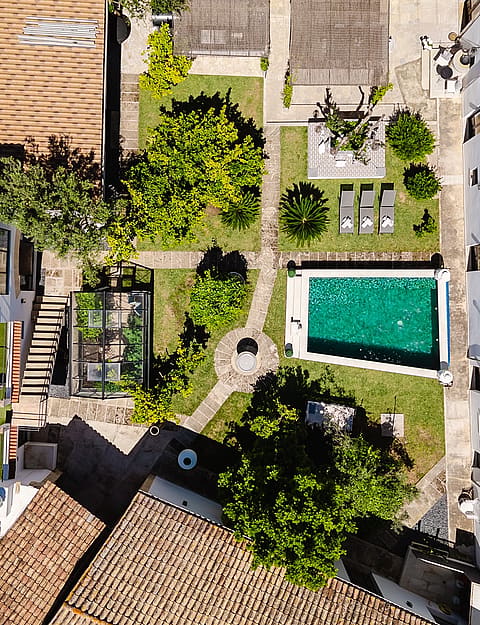 Direct overhead drone shot of a property in Sencelles, showing a rectangular swimming pool, garden areas, and white building rooftops.