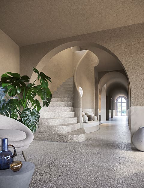 Interior foyer of a finca in Santa Maria featuring a curved stone staircase under an archway, textured walls, and a potted monstera plant.