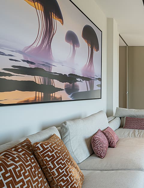Spacious living room featuring a large sectional sofa, glass coffee table, and large abstract wall art in a modern villa.