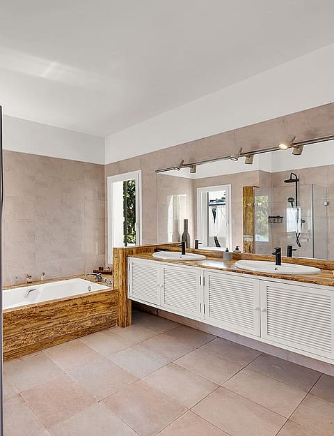 Modern bathroom featuring a glass-enclosed walk-in shower with matte black fixtures, a white soaking tub, and a wooden vanity.