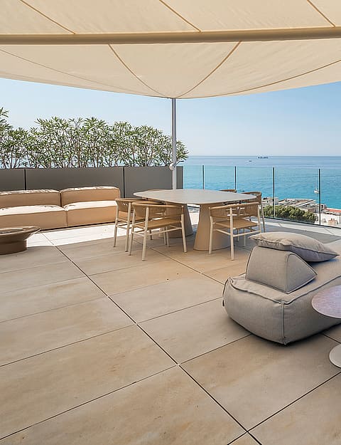 Rooftop terrace in Cala Mayor with a large shade canopy, lounge seating, and a dining area overlooking the Mediterranean Sea.