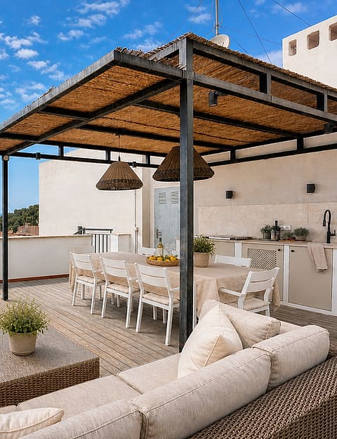 A spacious terrace in San Agustin with a shaded dining area, woven rattan sofa, and a stone-built outdoor kitchen.