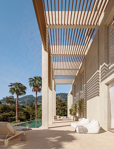 Contemporary stone terrace featuring a wooden slatted pergola casting linear shadows on a light facade beside a pool.