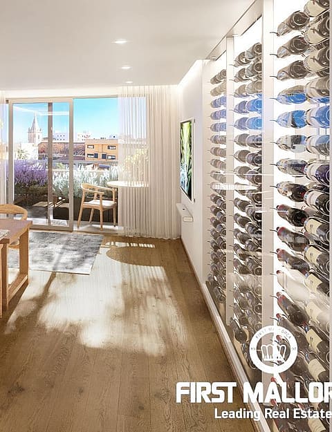 Modern open-plan kitchen featuring a grey island with granite countertop, floor-to-ceiling glass wine cellar, and light wood flooring.