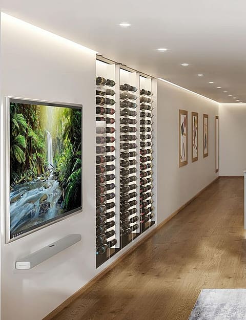 Modern open-plan living and kitchen space with integrated wine storage, wooden dining table, and contemporary sofa.