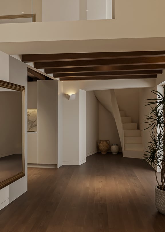 Evening view of a double-height living space with a curved staircase to a mezzanine, exposed wooden beams, oak flooring and a tall potted plant.