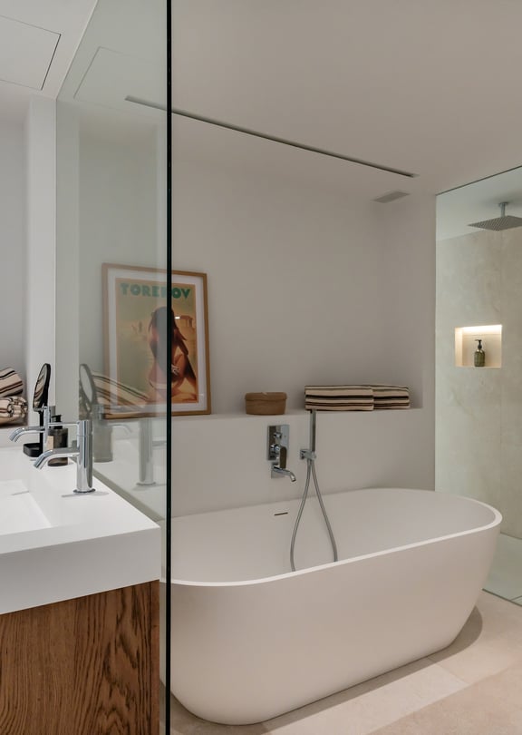 En-suite bathroom with large-format stone tiles, walk-in glass shower with rainfall head and vessel basin on timber vanity unit