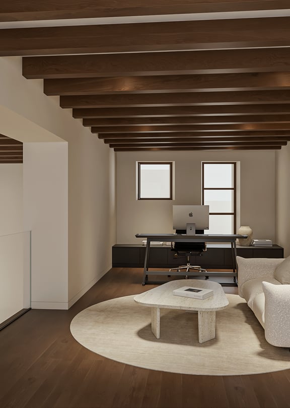 Mezzanine used as a home office with desk and sofa, glass balustrade and exposed dark timber beams overlooking the level below.