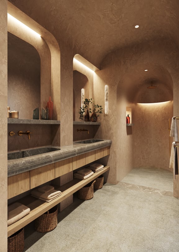 A master bathroom featuring a long stone vanity with double sinks, warm cove lighting, and an arched walk-in shower.
