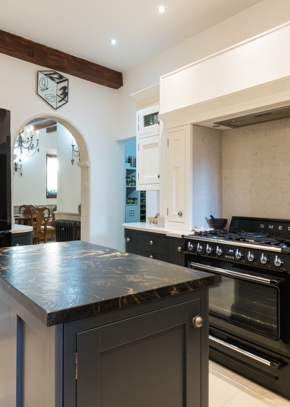 Kitchen with black cabinetry, marble-topped island and black SMEG range cooker