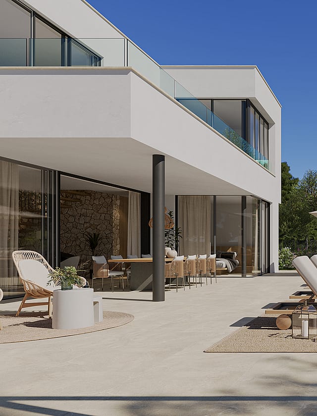 Wide angle view of a sun-drenched outdoor terrace with lounge chairs, a rectangular swimming pool, and stone wall features.