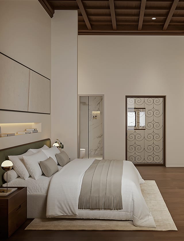 Principal bedroom with green upholstered headboard, coffered wooden ceiling, fitted wardrobes and an en-suite with marble shower through the doorway.
