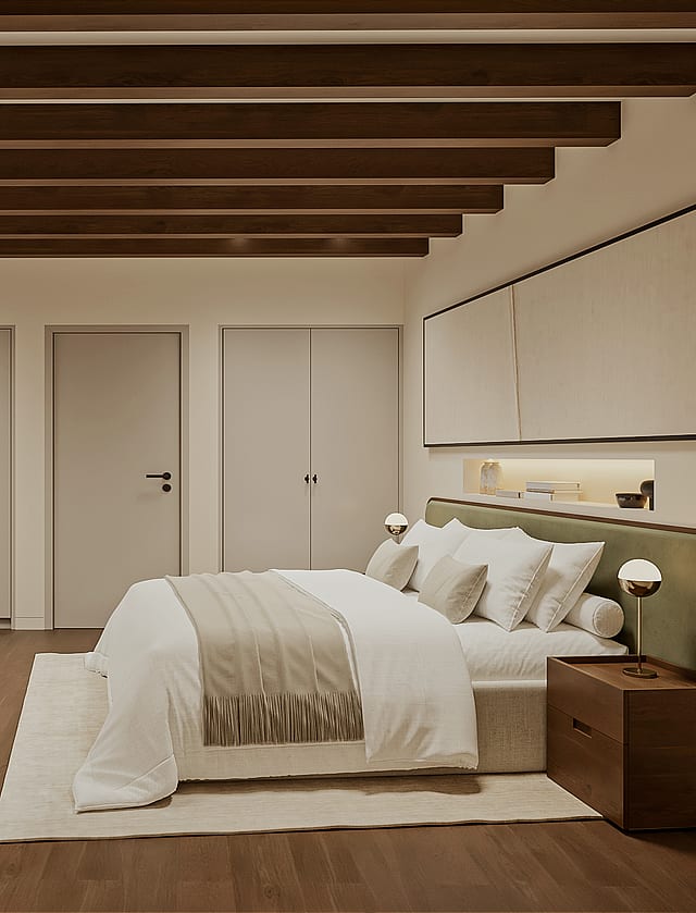 Double bedroom with green upholstered headboard, beamed ceiling, fitted wardrobes and an open door revealing a staircase with iron balustrade.