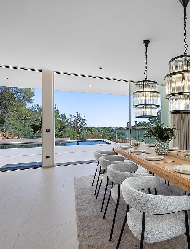 Dining room with statement pendants and retractable glass wall to the pool terrace