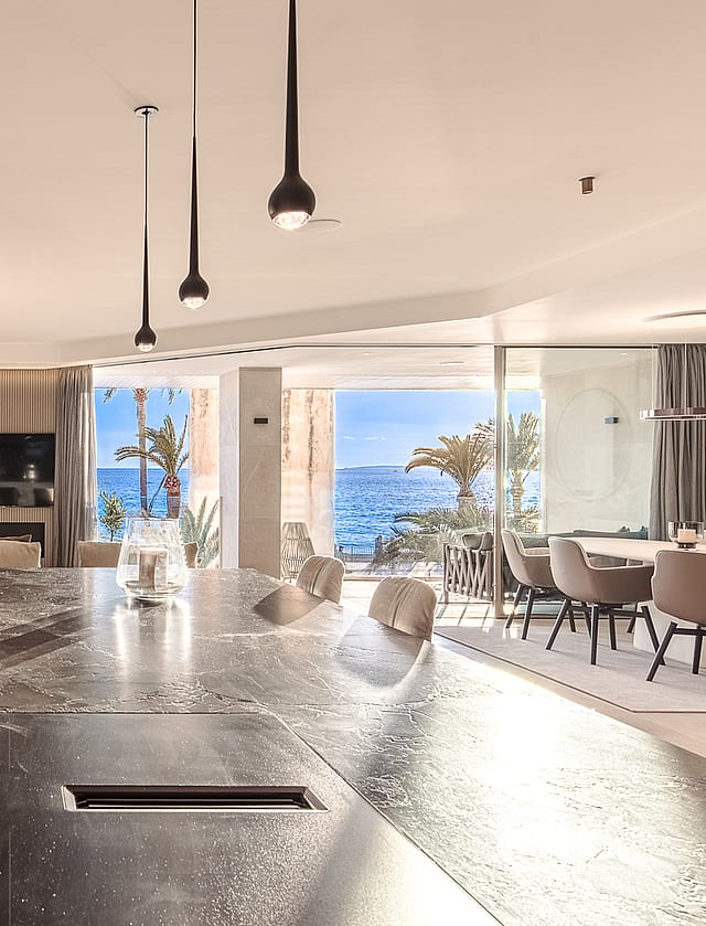 Dining area with marble countertops, designer pendant fixtures and seamless access to the waterfront loggia