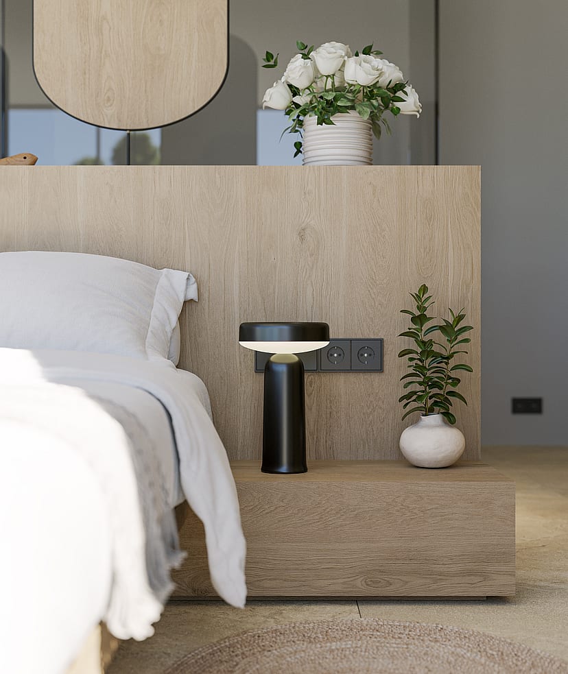 Close-up of a modern bedside setup with a textured oak headboard, black designer lamp, and a small ceramic vase.