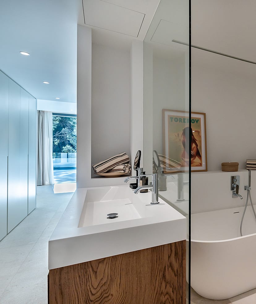 En-suite bathroom with large-format stone tiles, walk-in glass shower with rainfall head and vessel basin on timber vanity unit