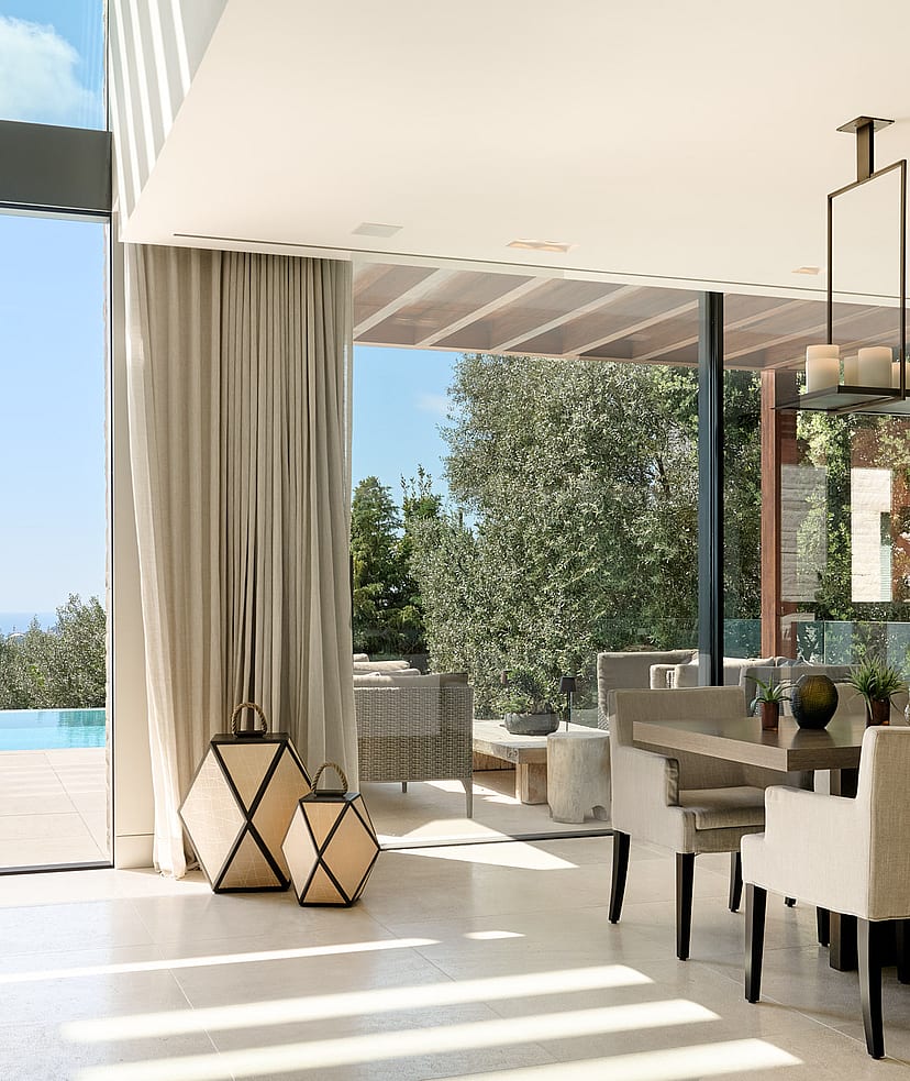 Open-plan living and dining room with natural-toned furnishings and large glazing