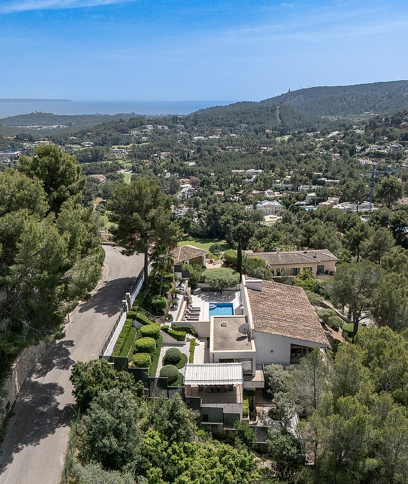 Elevated view from Son Vida villa across green pine-covered hillside toward Palma Bay and the Mediterranean