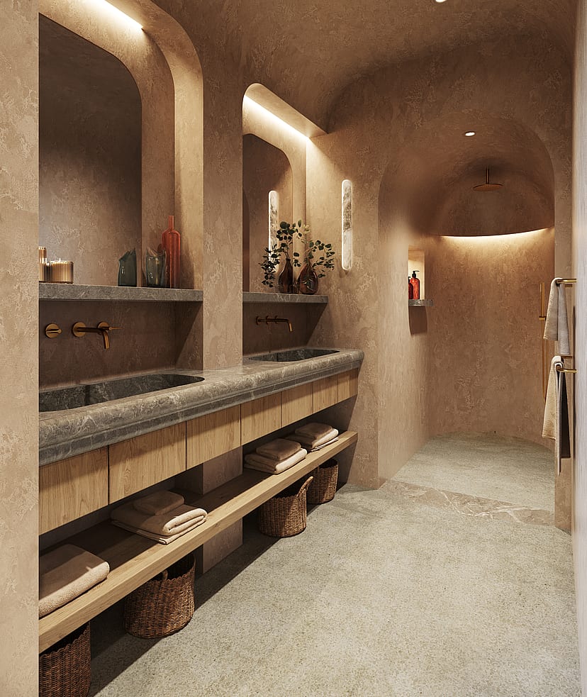 A master bathroom featuring a long stone vanity with double sinks, warm cove lighting, and an arched walk-in shower.