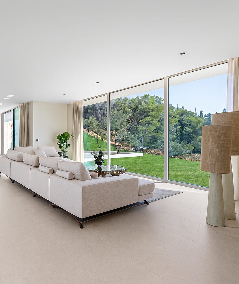 Spacious living area with oversized sectional sofa and full-height sliding glass to pool terrace