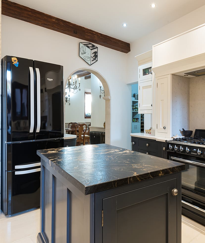 Kitchen with black cabinetry, marble-topped island and black SMEG range cooker