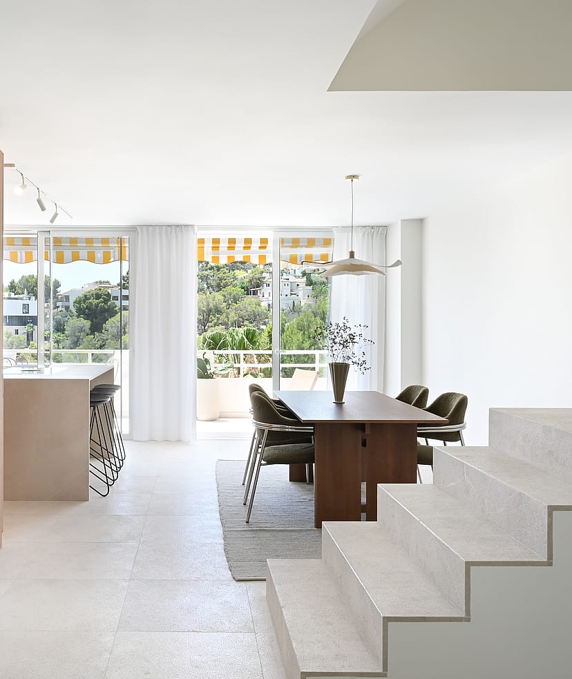 Living room with linen sofa, walnut coffee table, and floor-to-ceiling glazing framing seaview terrace