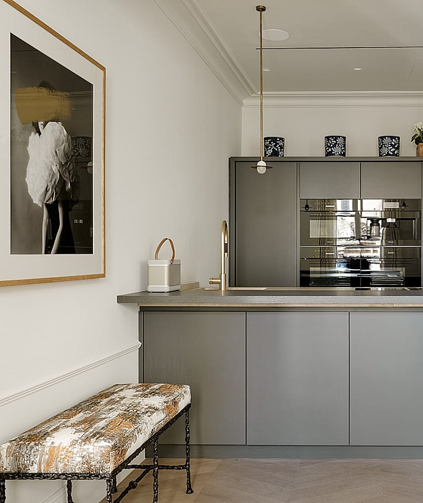 Contemporary kitchen featuring grey-toned cabinetry, professional-grade stainless steel appliances, white countertop, and brass pendant lights