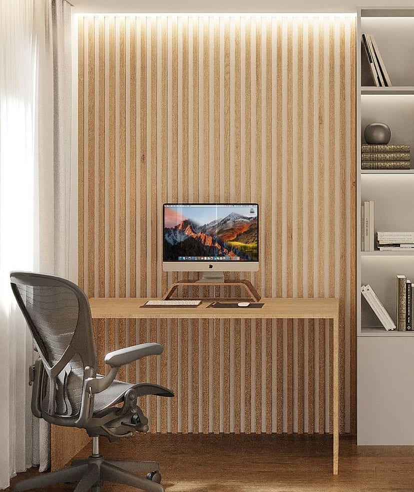 A home office featuring a slatted light oak wood wall, a minimalist desk, an ergonomic mesh office chair, and built-in shelving.
