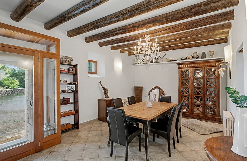 Rustic dining room with exposed wooden ceiling beams and terracotta floor tiles