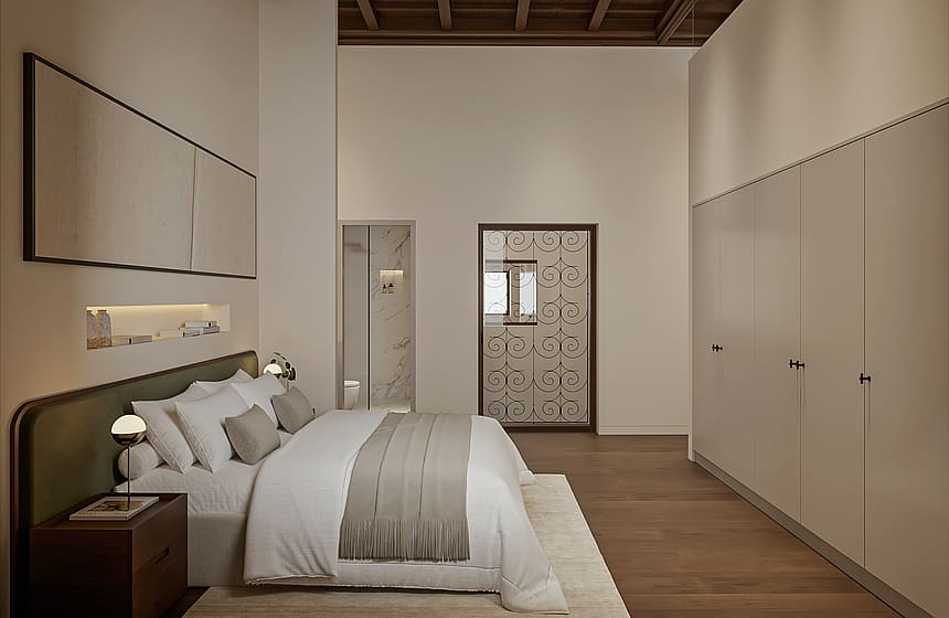 Principal bedroom with green upholstered headboard, coffered wooden ceiling, fitted wardrobes and an en-suite with marble shower through the doorway.