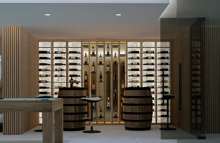 A modern wine cellar featuring backlit stone display walls, two wooden wine barrels used as tables, and bar stools.