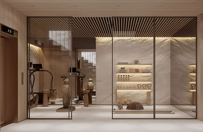 Interior view of a modern wellness facility featuring glass-partitioned sauna, gym equipment, and integrated warm lighting.