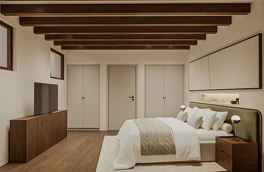 Double bedroom with green upholstered headboard, beamed ceiling, fitted wardrobes and an open door revealing a staircase with iron balustrade.